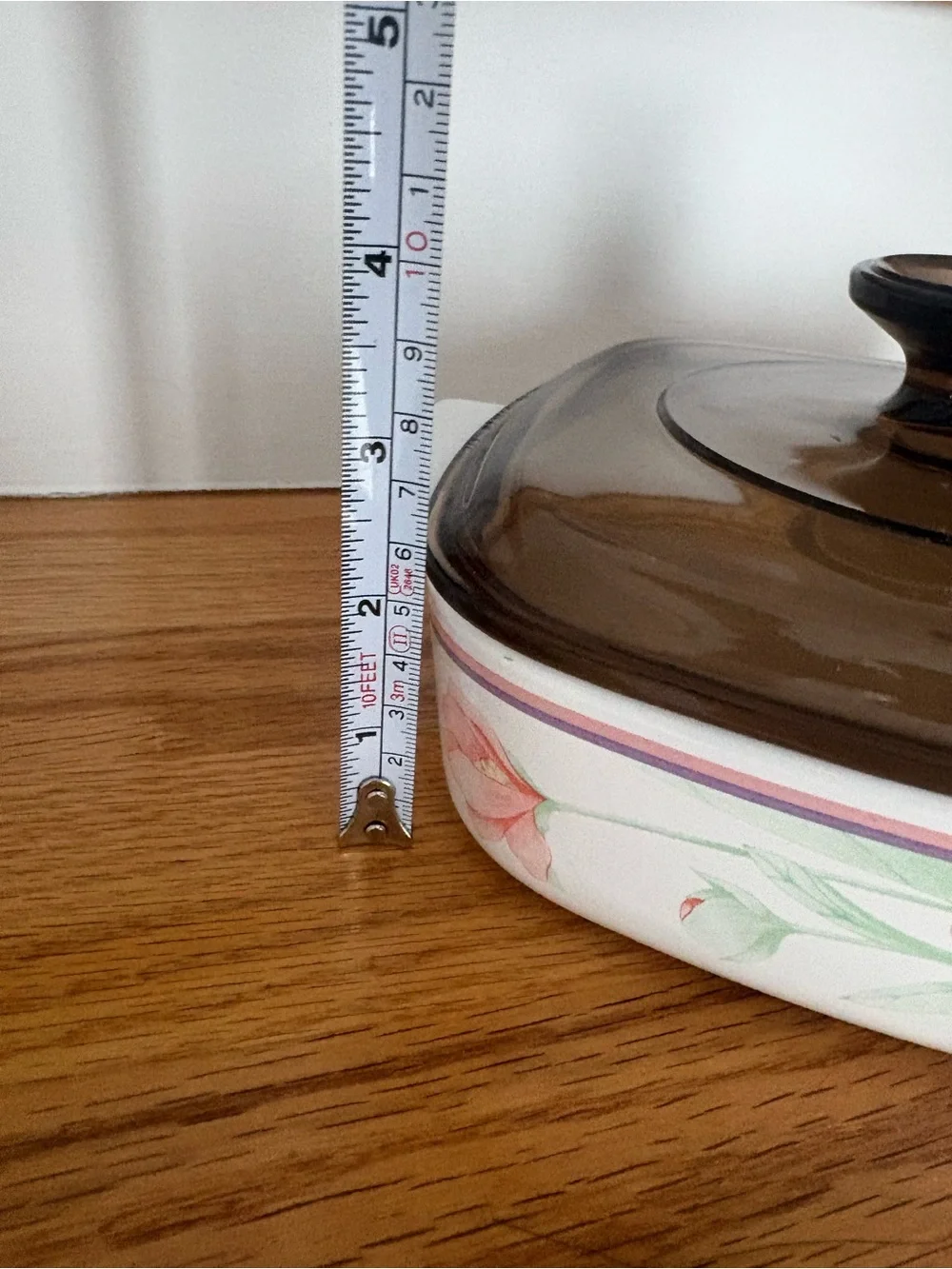 A vintage Corning Ware casserole dish in the Peony Floral pattern with lid